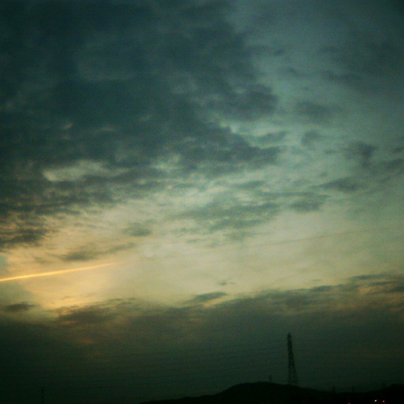 夕日に光る飛行機雲