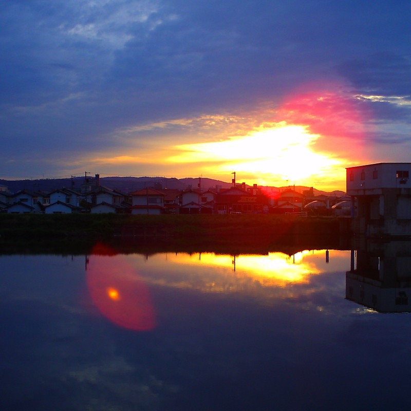 水面に写る水門と夕日