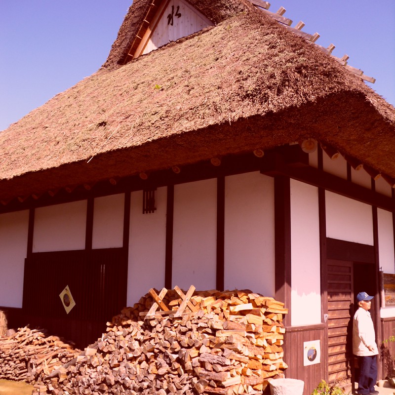 茅葺き屋根の古民家と薪とオヤジさん